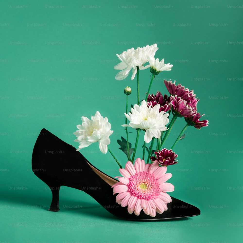 a pair of black high heels with flowers in them