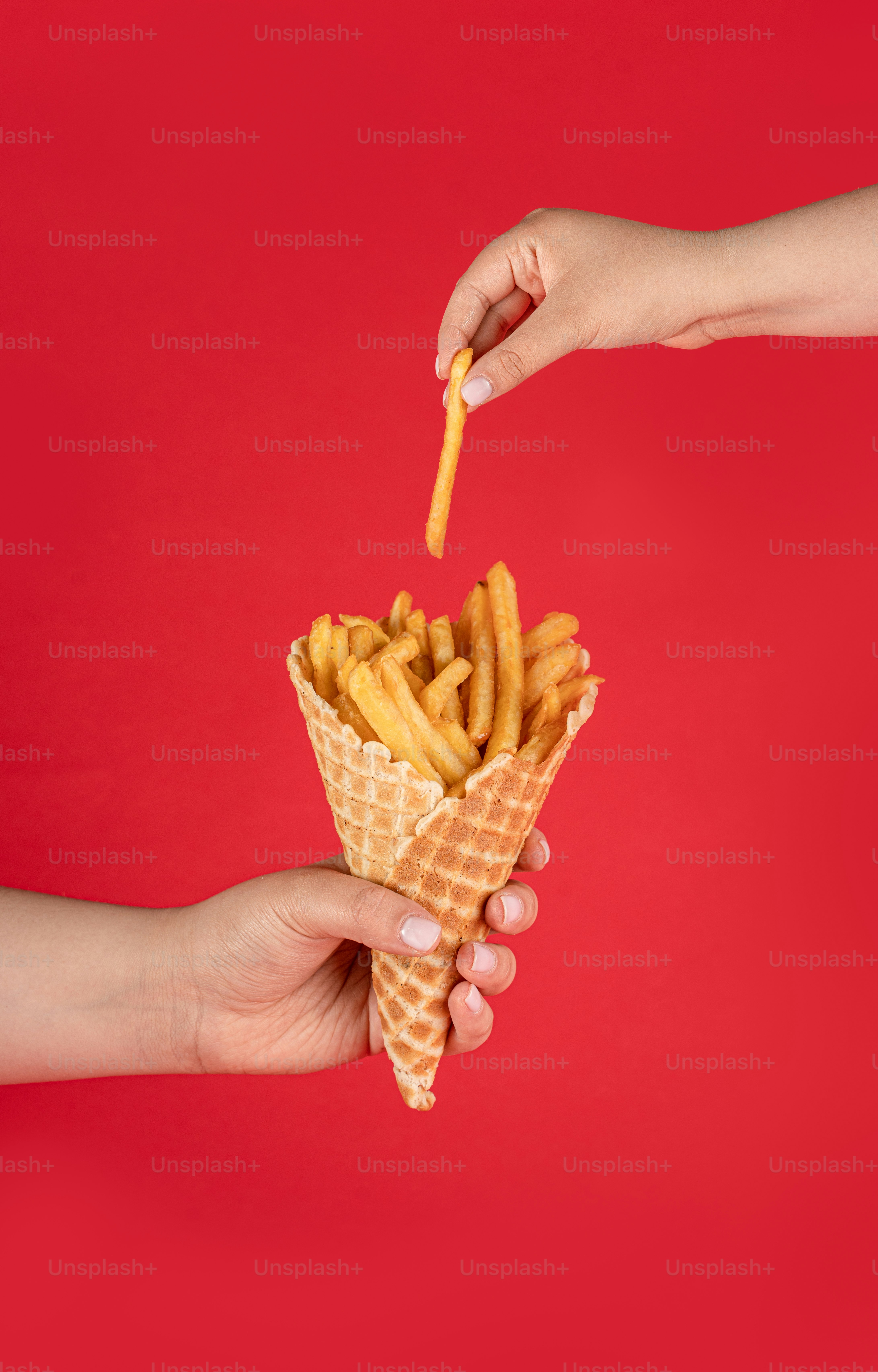 Una mano che tiene una cialda ripiena di patatine fritte