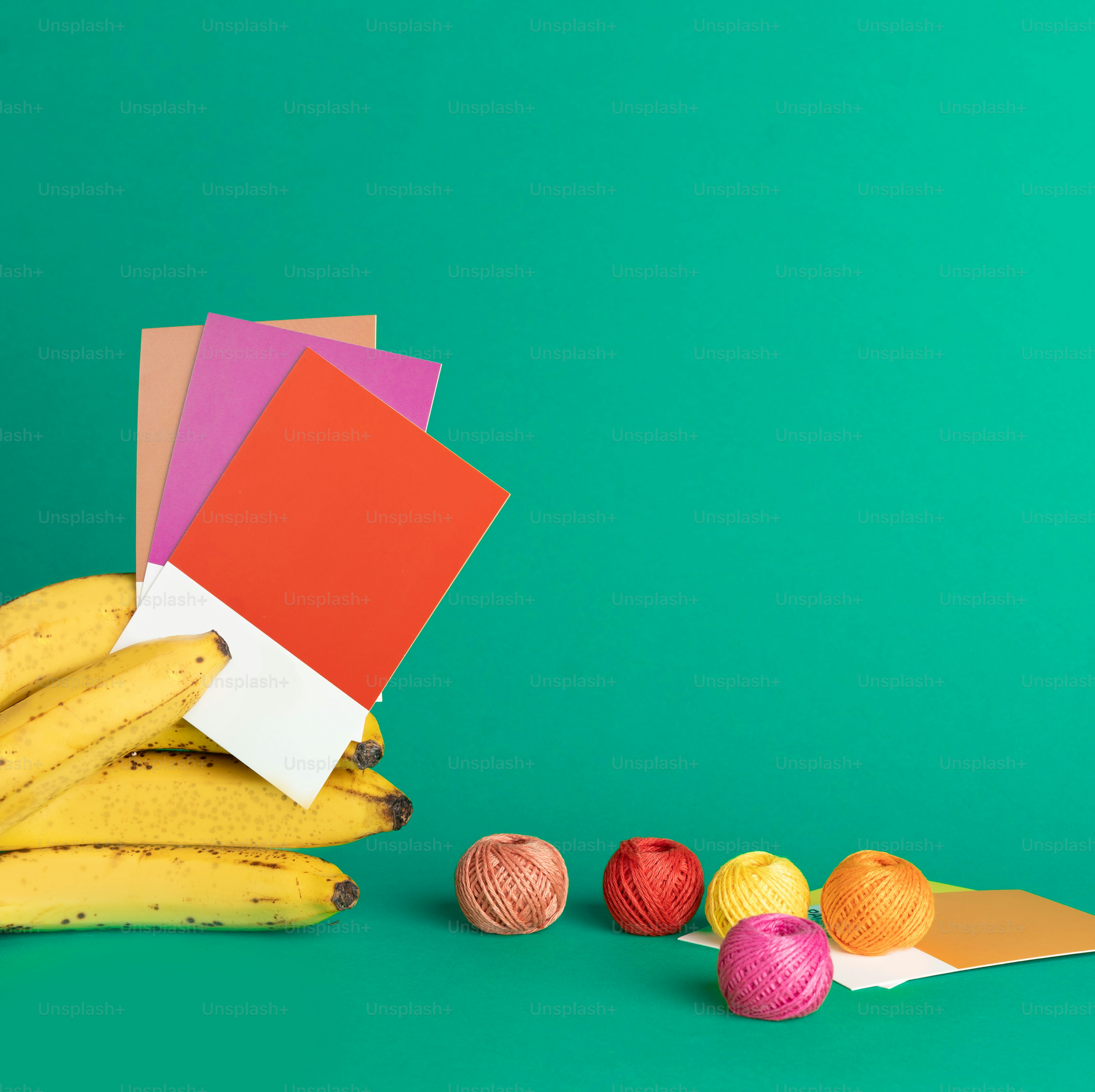 ein Bündel Bananen, die neben Garnknäueln sitzen