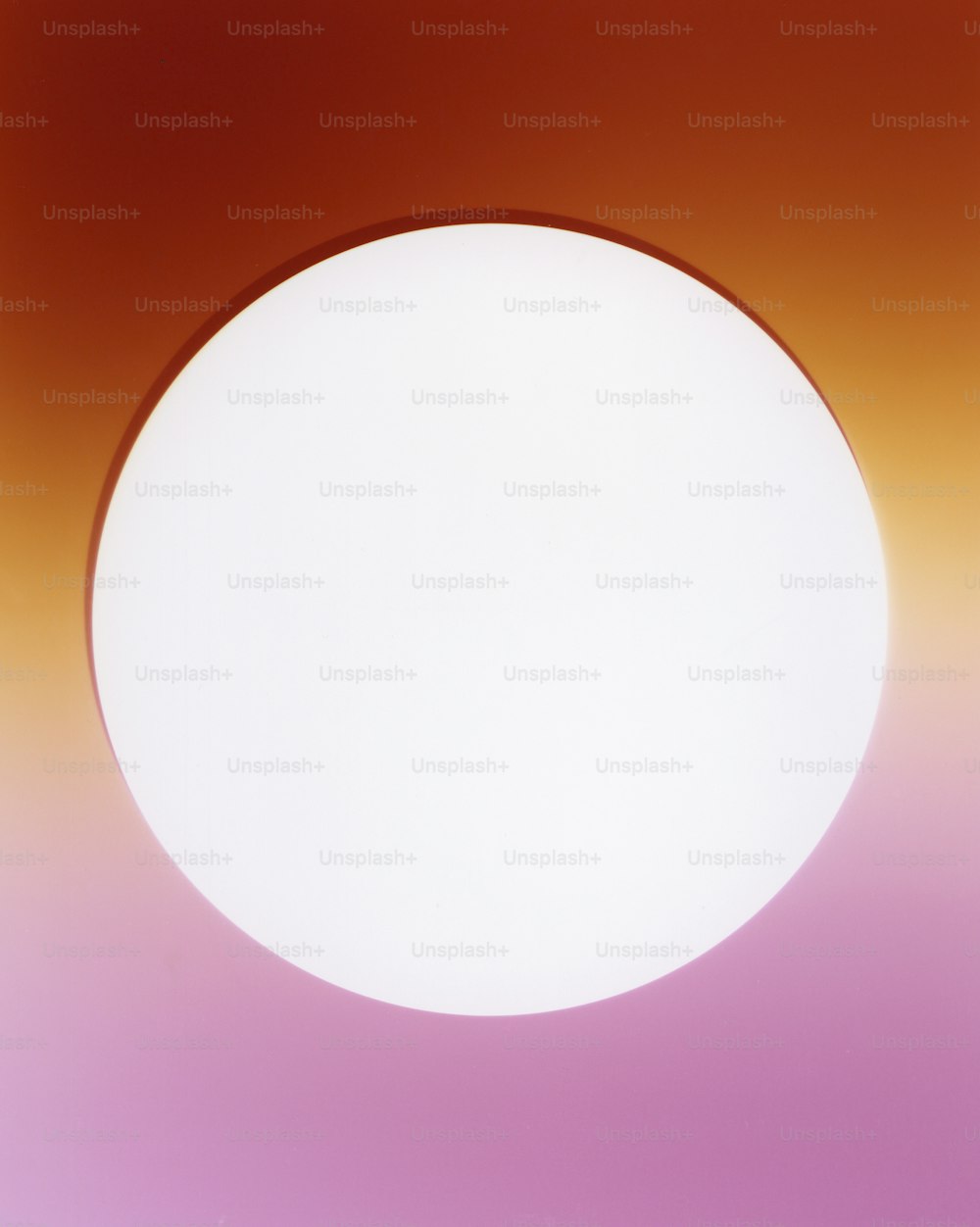 a white circle on a pink and orange background