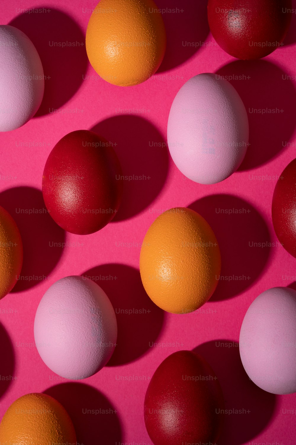 a group of eggs sitting next to each other on a pink surface