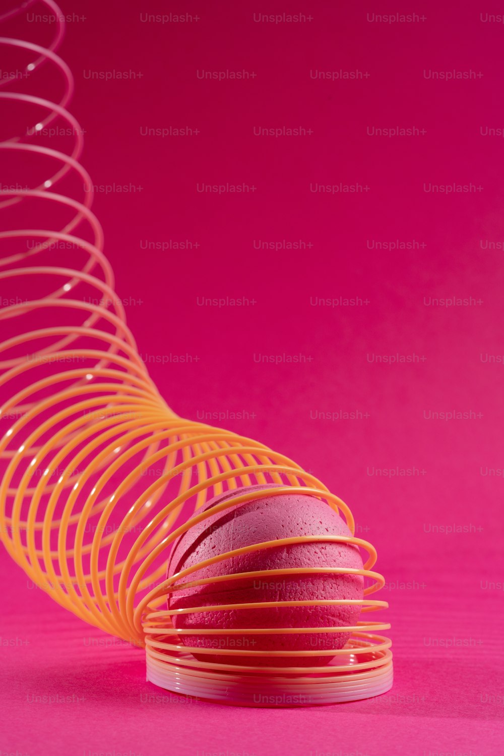 a pink and yellow object on a pink background