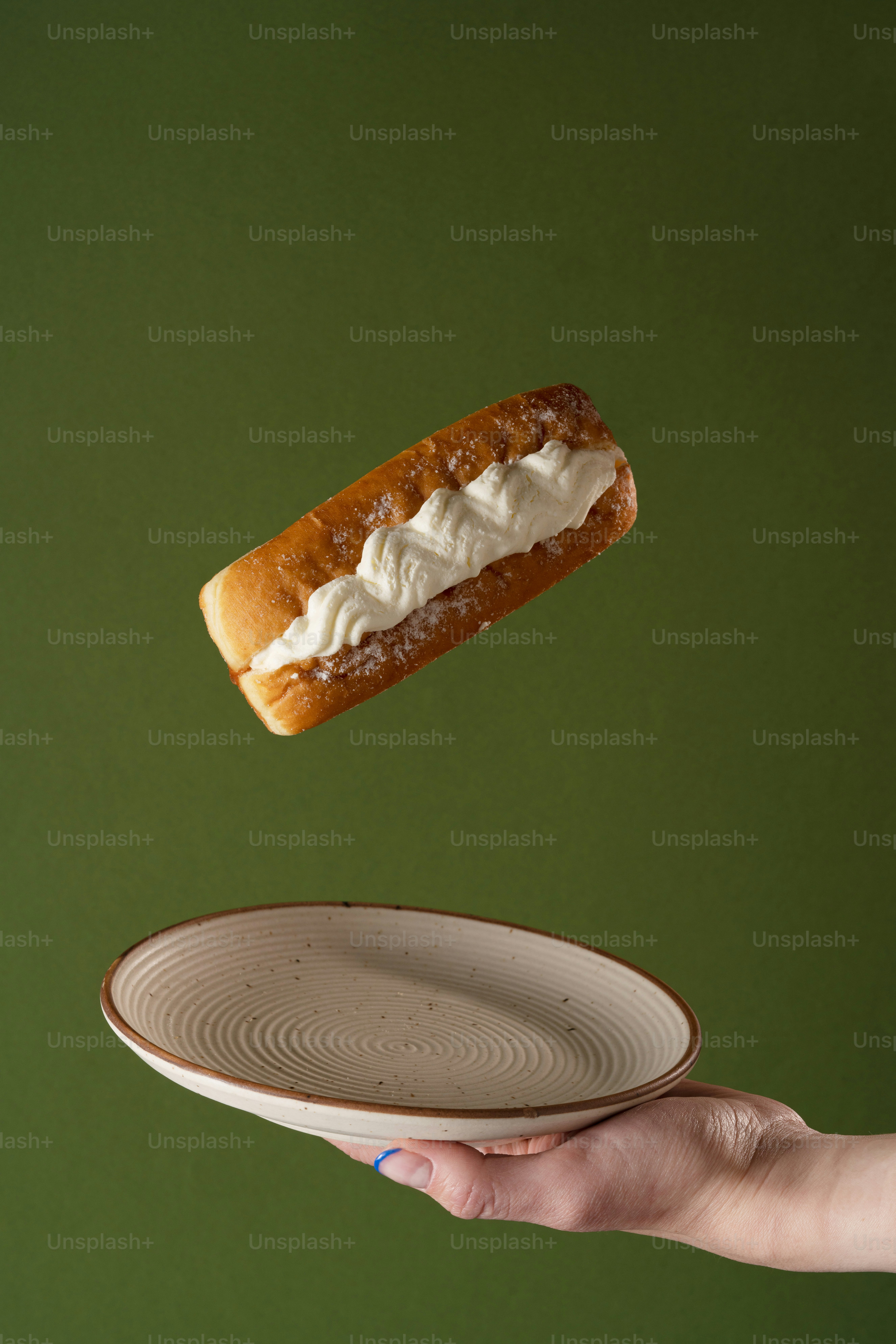 a person holding a plate with a hot dog on it