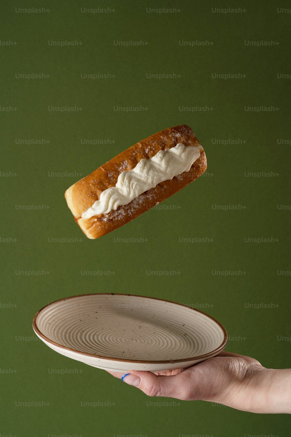 a person holding a plate with a hot dog on it