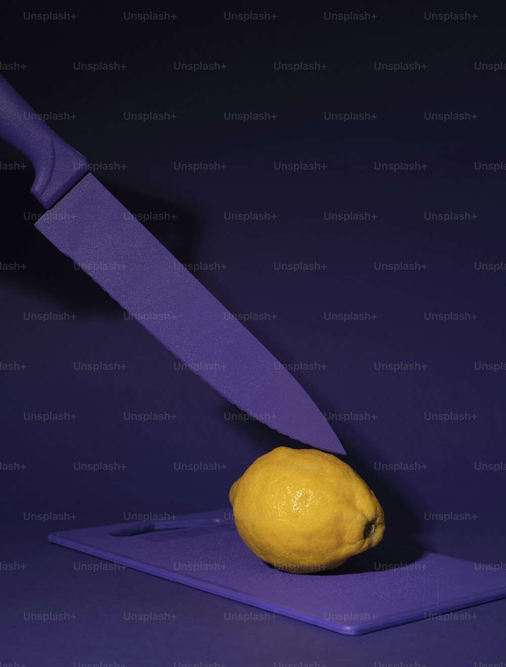 a purple cutting board with a lemon on it