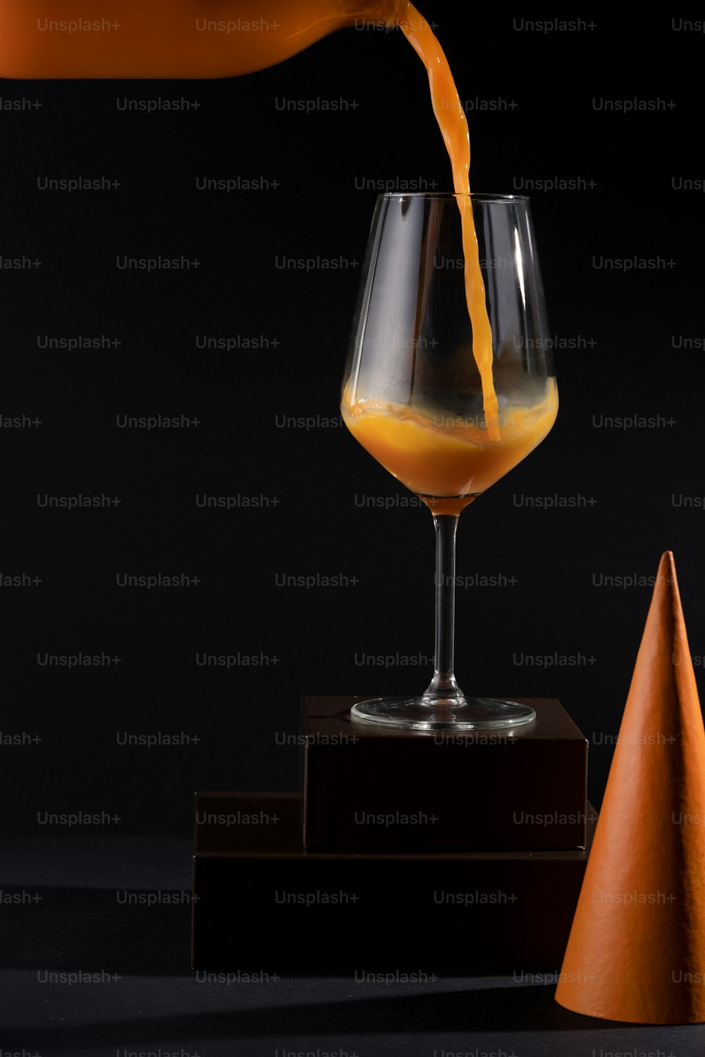une personne versant du jus d’orange dans un verre de vin