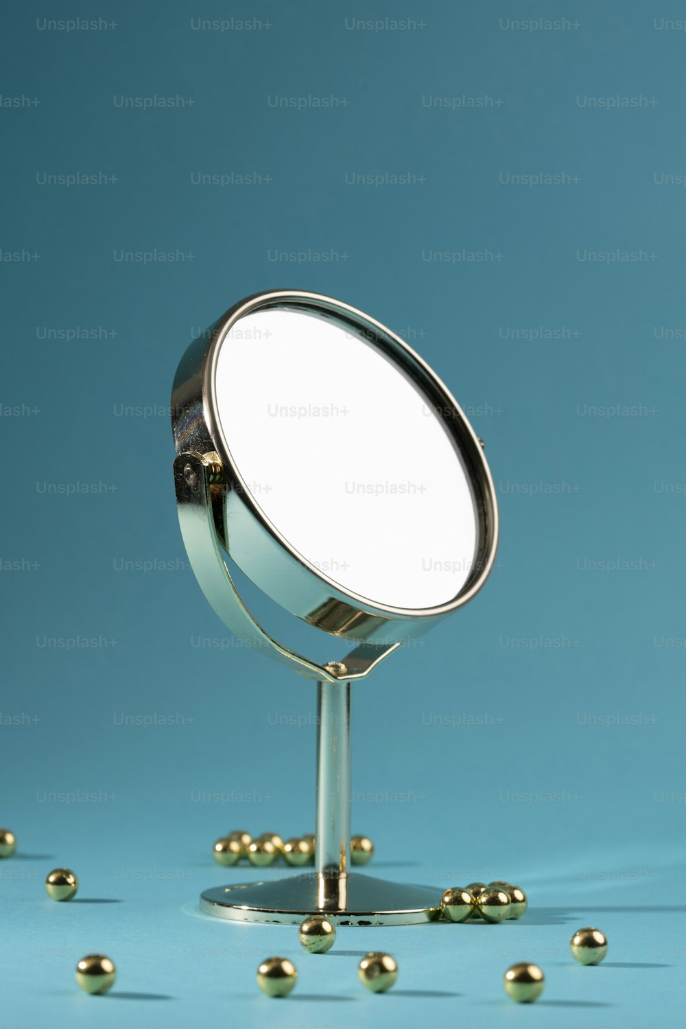 a mirror on a stand with balls around it