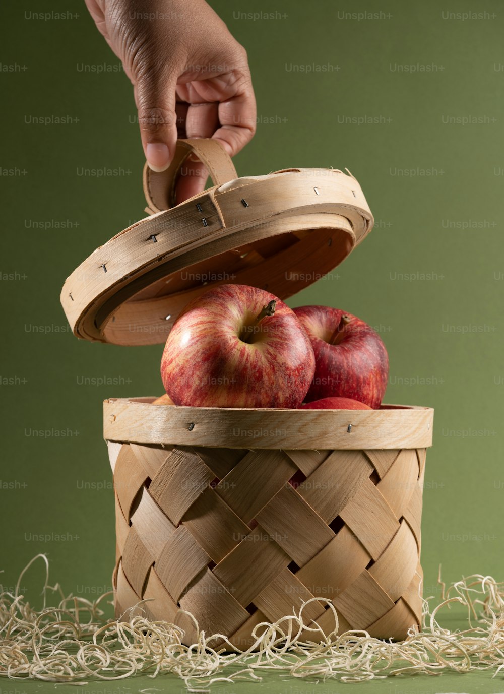uma pessoa colocando uma maçã em uma cesta