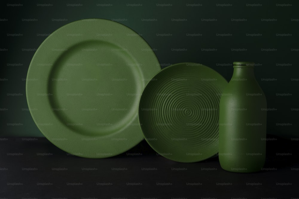 ein grüner Teller und eine grüne Vase auf einem Tisch