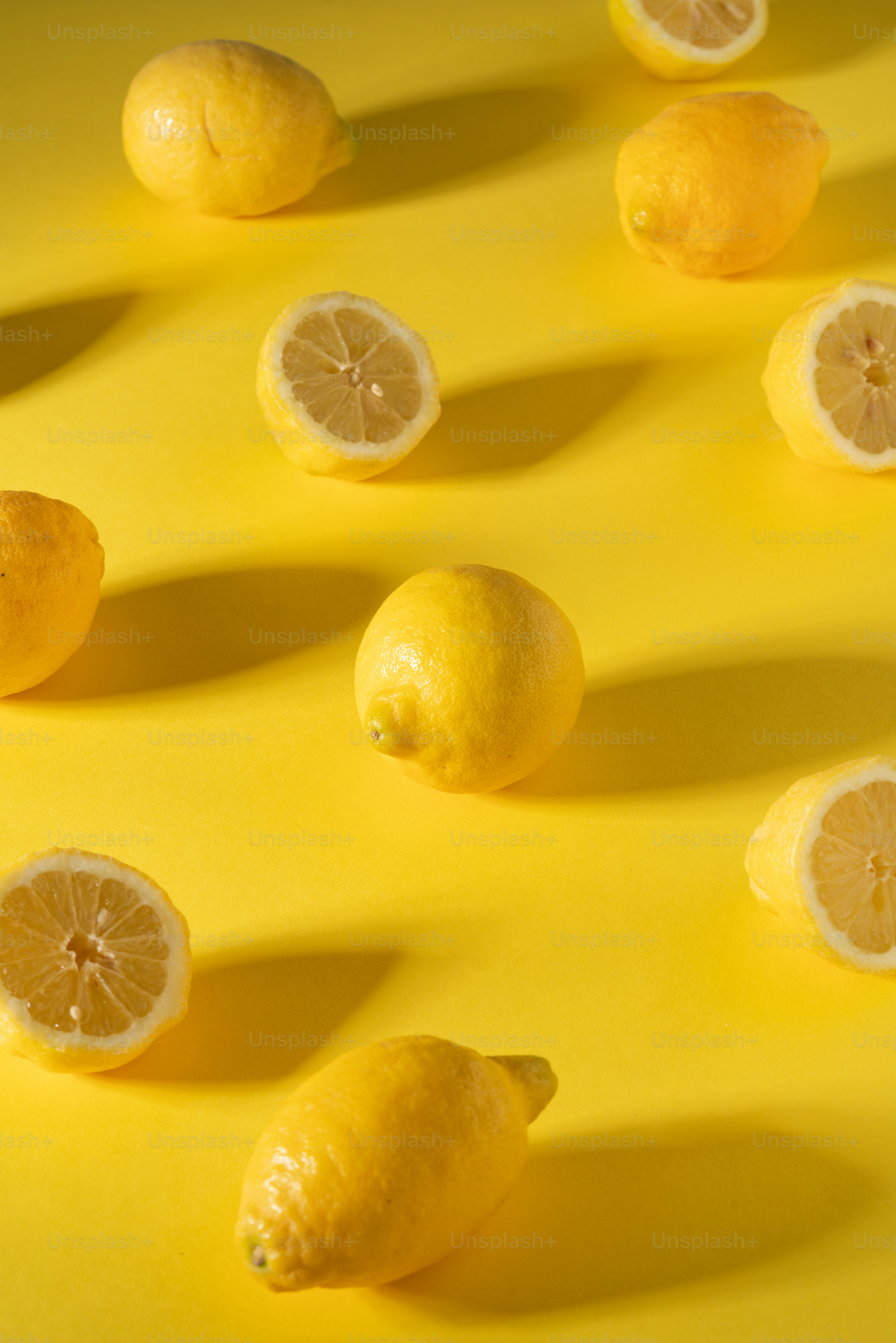 Un grupo de limones sentados encima de una superficie amarilla