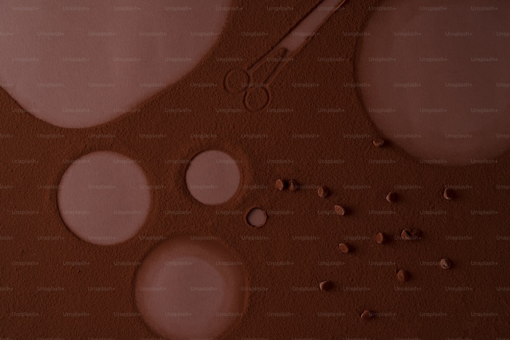 a close up of a brown surface with circles and a pair of scissors