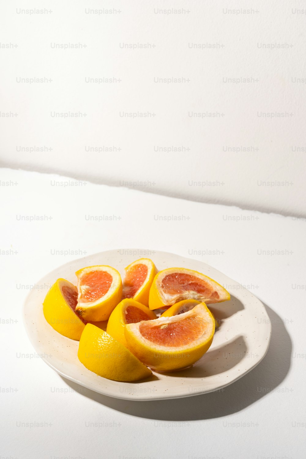 a white plate topped with sliced oranges on top of a table