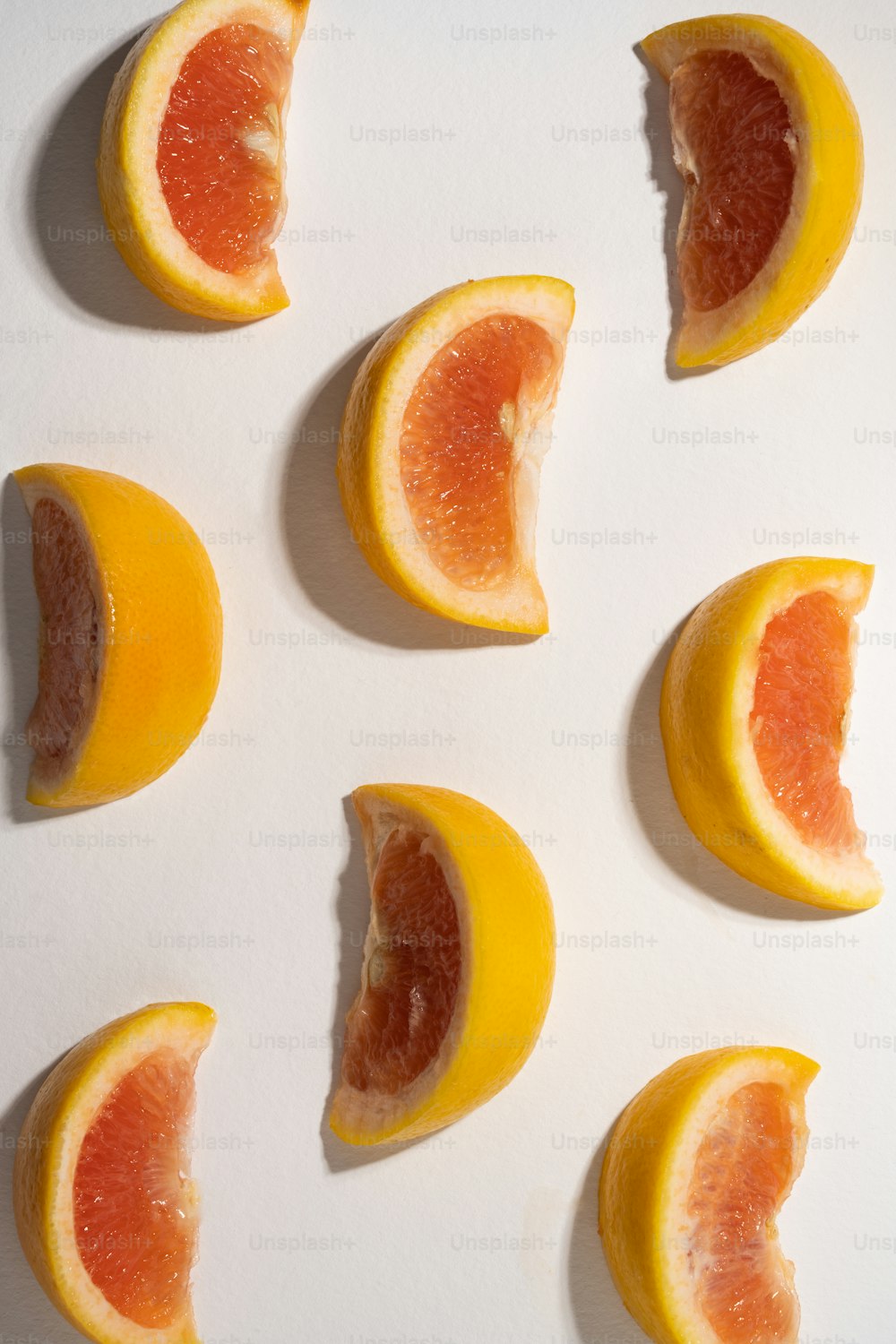 eine Gruppe von Grapefruits, die auf einer weißen Fläche in zwei Hälften geschnitten sind