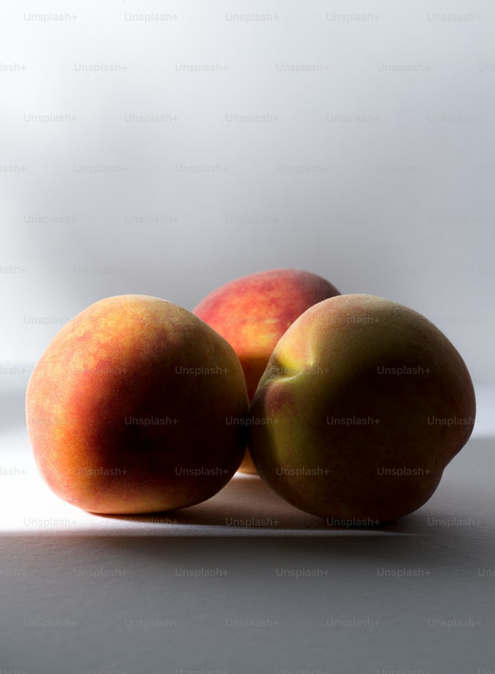 three peaches sitting on top of each other on a table