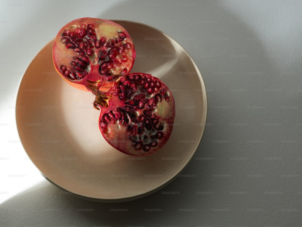 zwei Granatäpfel auf einem Teller auf einem Tisch