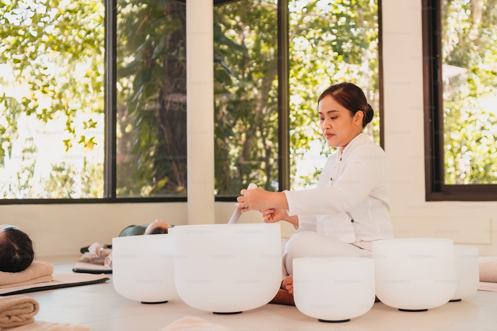 Una donna in camice bianco seduta su un tavolo