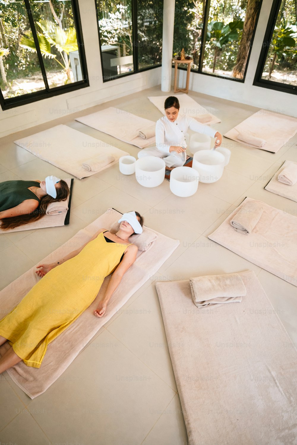 a group of people laying on mats in a room