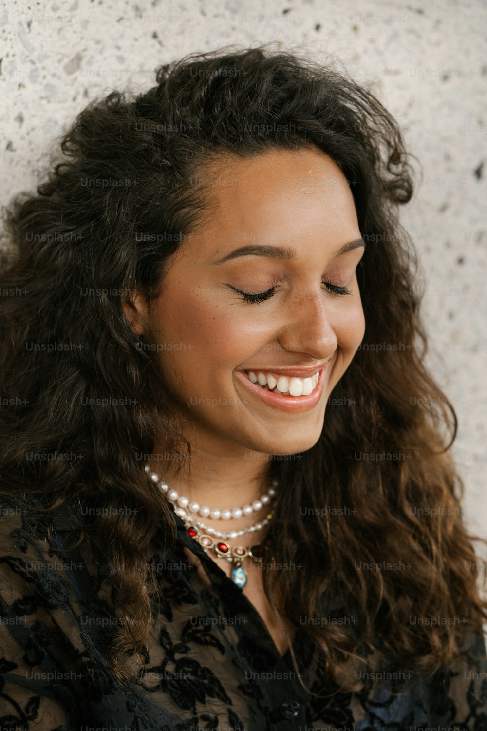 a woman smiling while looking at her cell phone