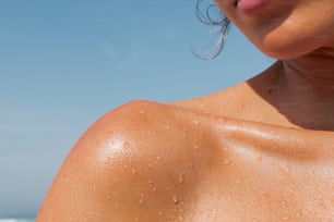 a close up of a woman's shoulder with water droplets on it
