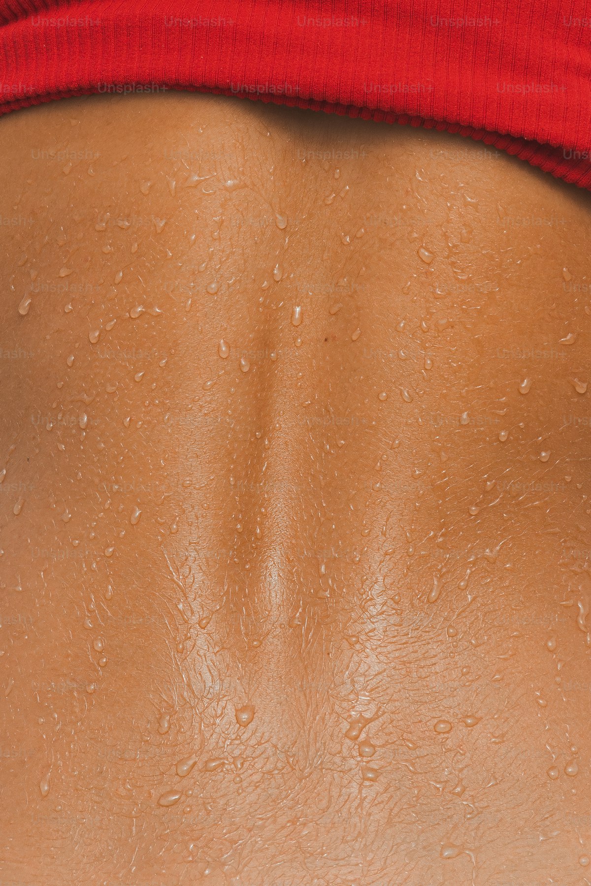 Close-up of a woman's back with water drops on the skin after immersion