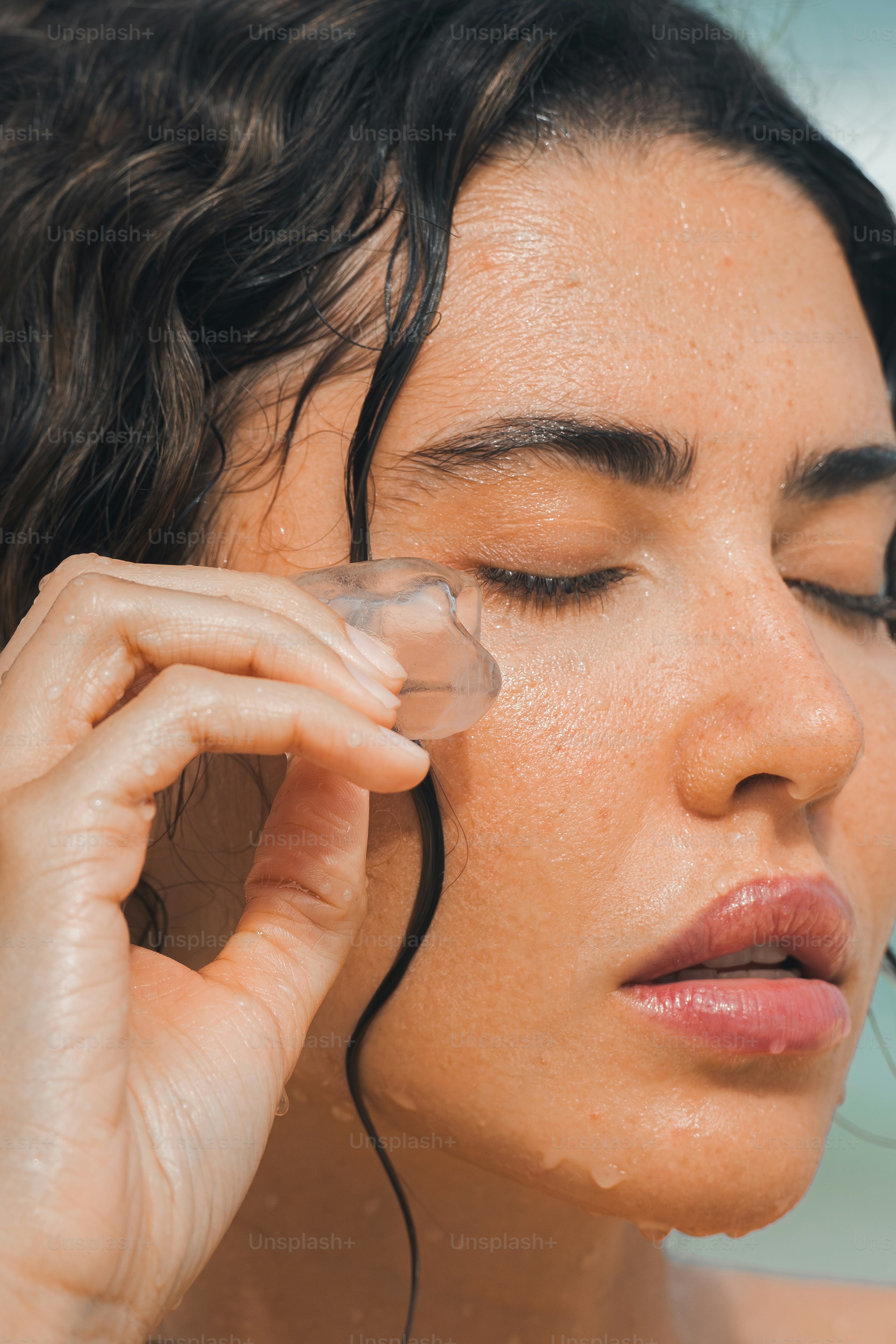 a close up of a woman holding a cell phone to her ear