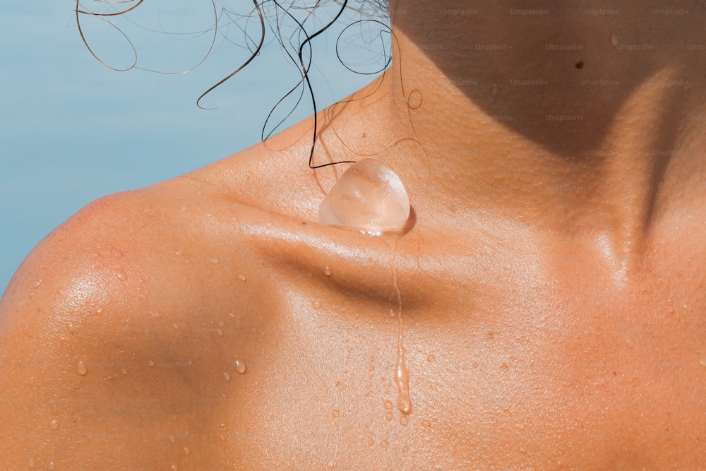 a close up of a person's chest with a drop of water on it