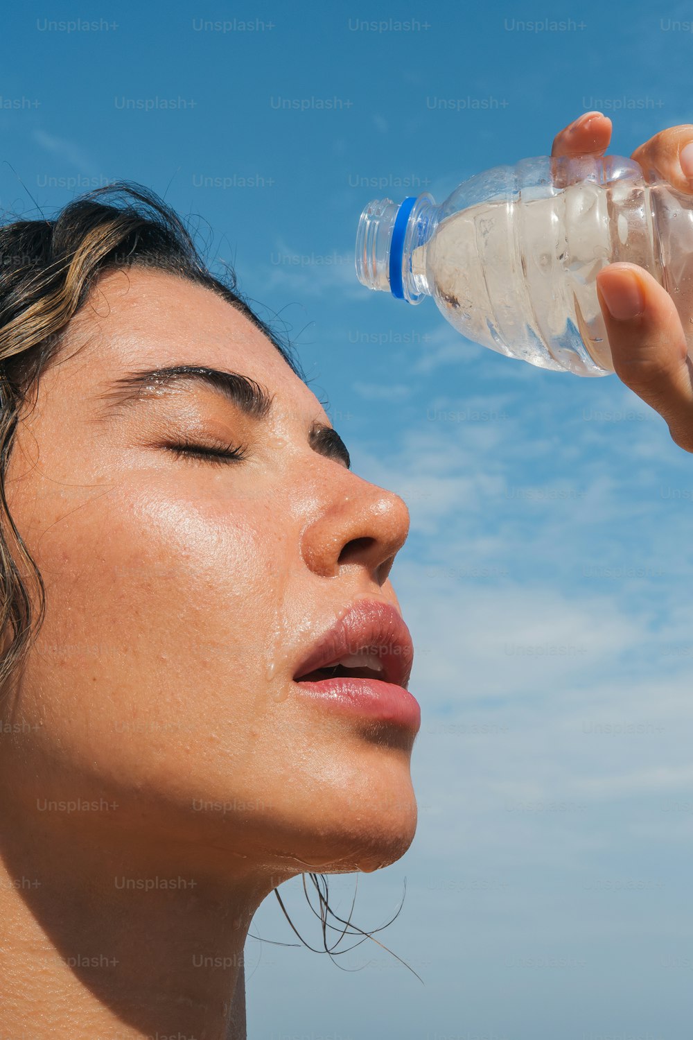 uma mulher bebendo água de uma garrafa