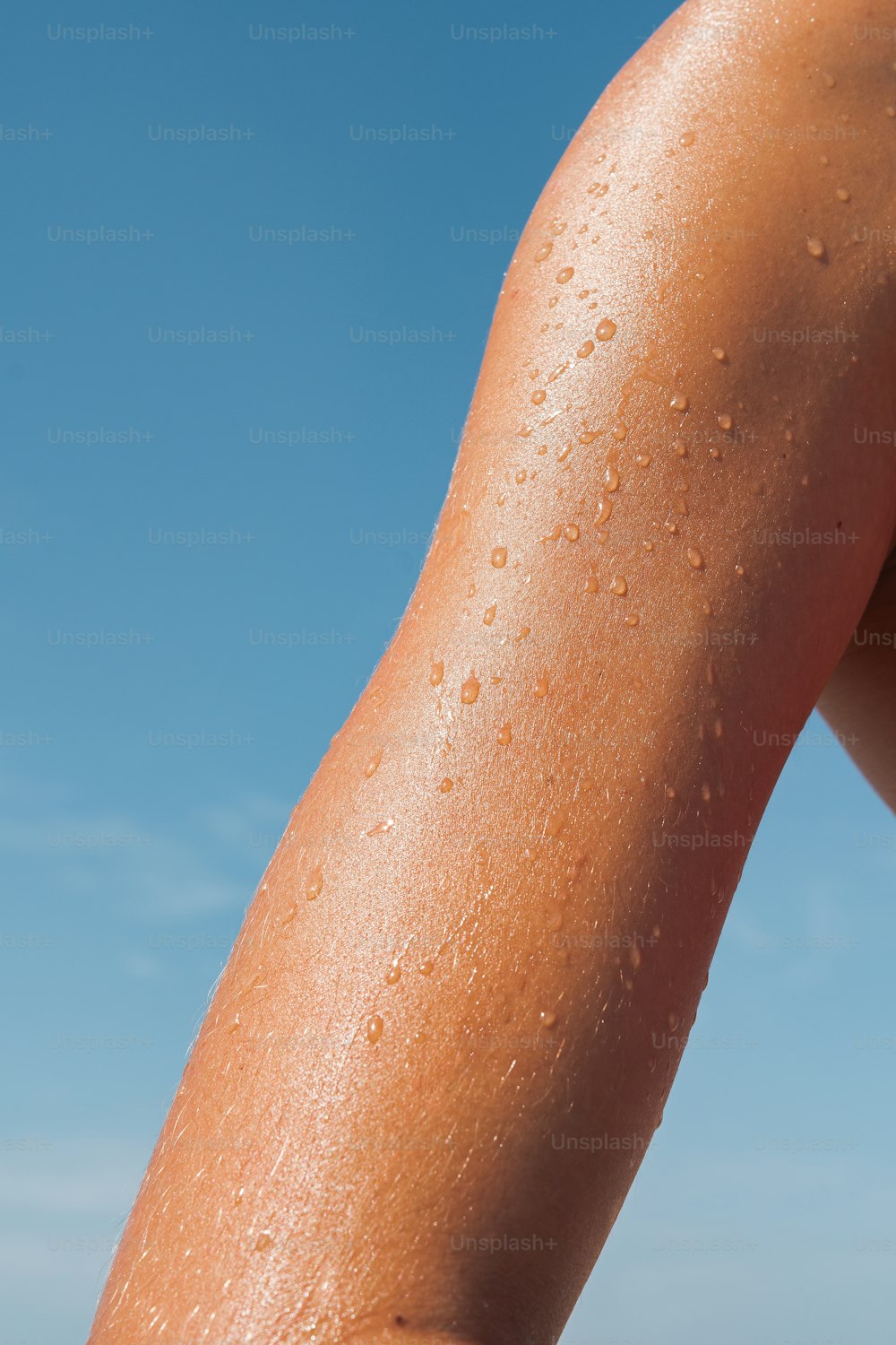 um close up do braço de uma pessoa com gotículas de água sobre ele