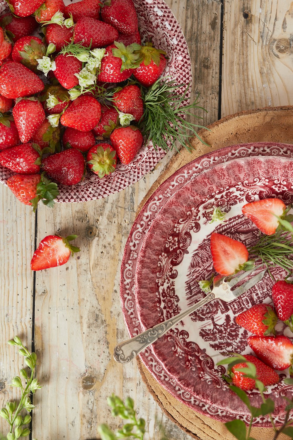 a bowl of strawberries and a plate of strawberries
