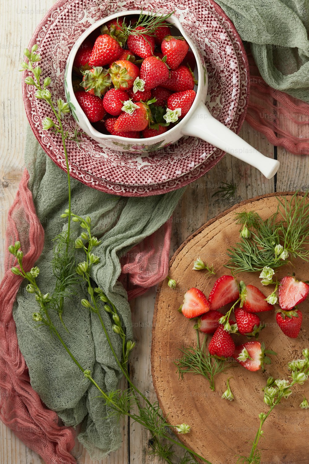 a bowl of strawberries on a wooden table