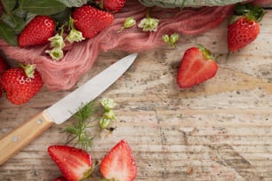 a knife and some strawberries on a table