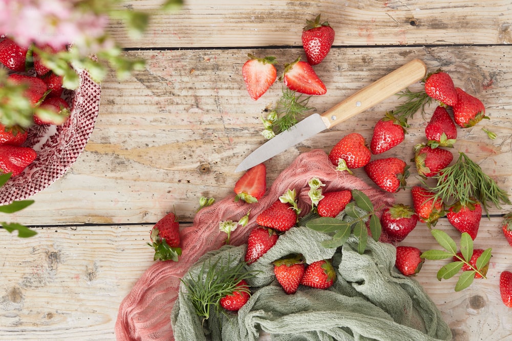 ein Messer und ein paar Erdbeeren auf einem Tisch