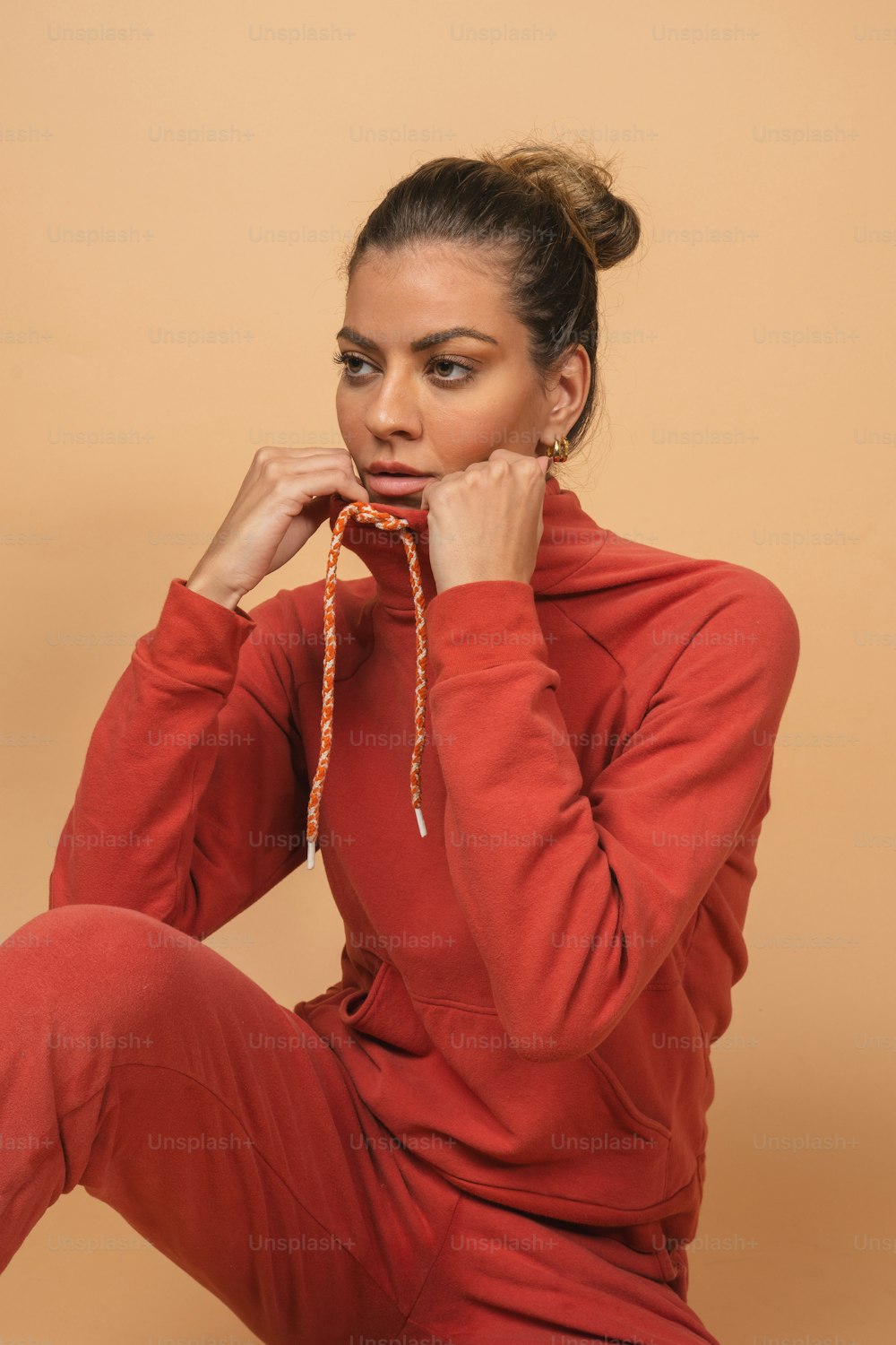 a woman sitting on the ground with her hands on her face