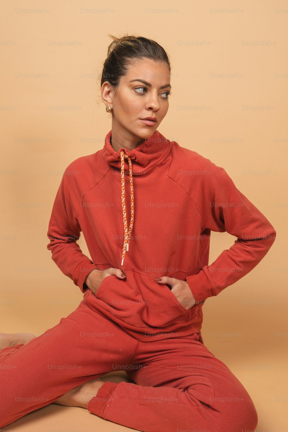 a woman sitting on the ground wearing a red outfit