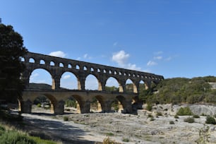 un pont de pierre au-dessus d’une rivière entourée d’arbres