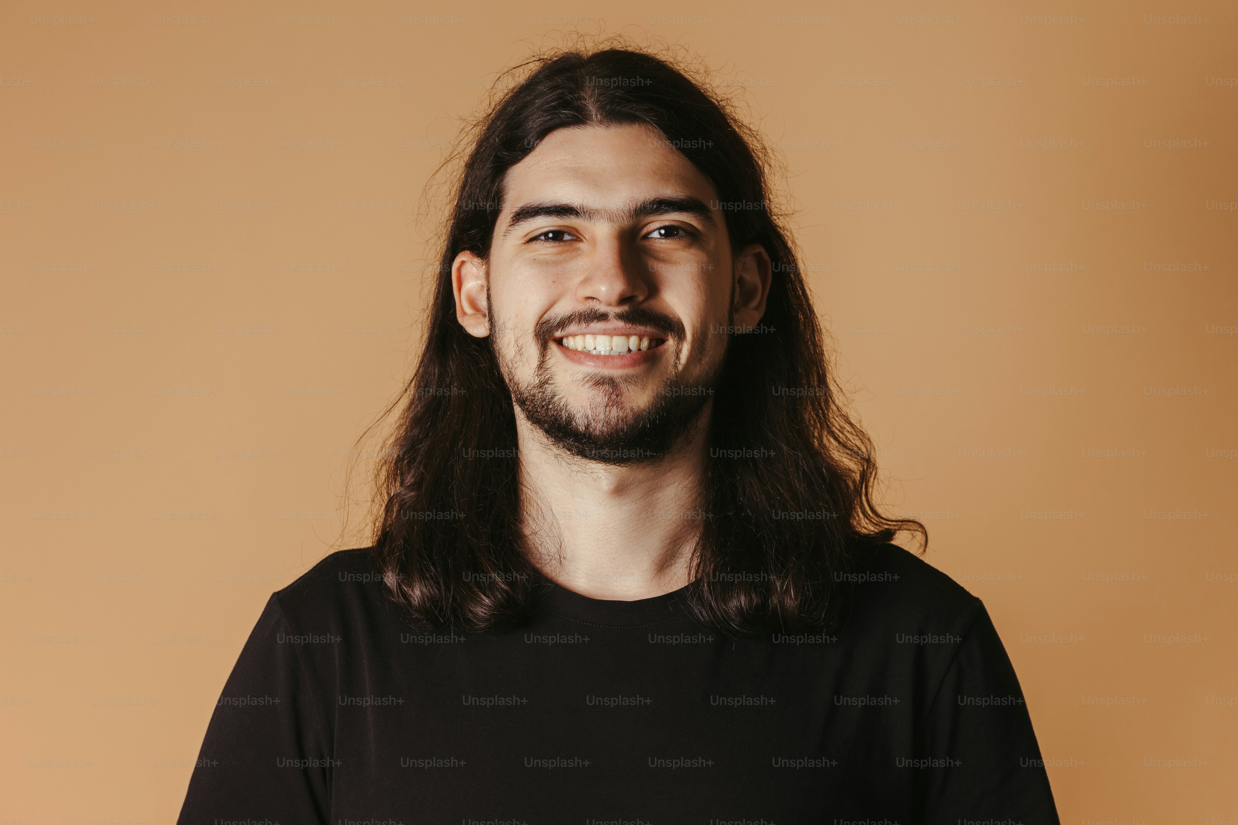 a man with long hair and a beard smiling