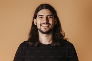 Un uomo con i capelli lunghi e la barba sorridente
