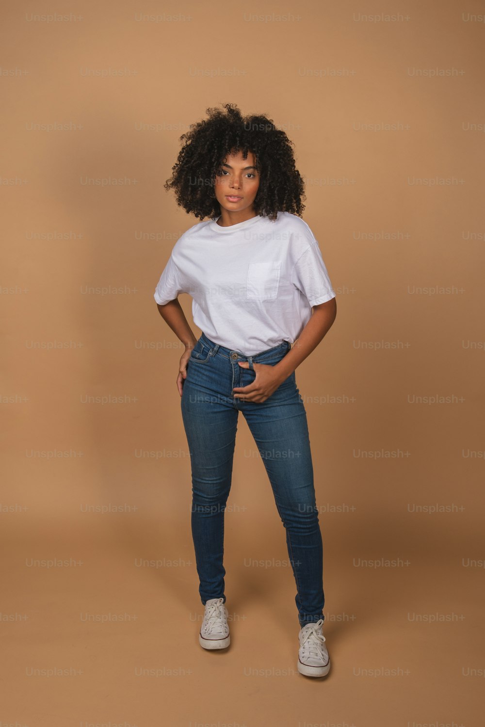 uma mulher posando para uma foto com uma camisa branca e calça jeans