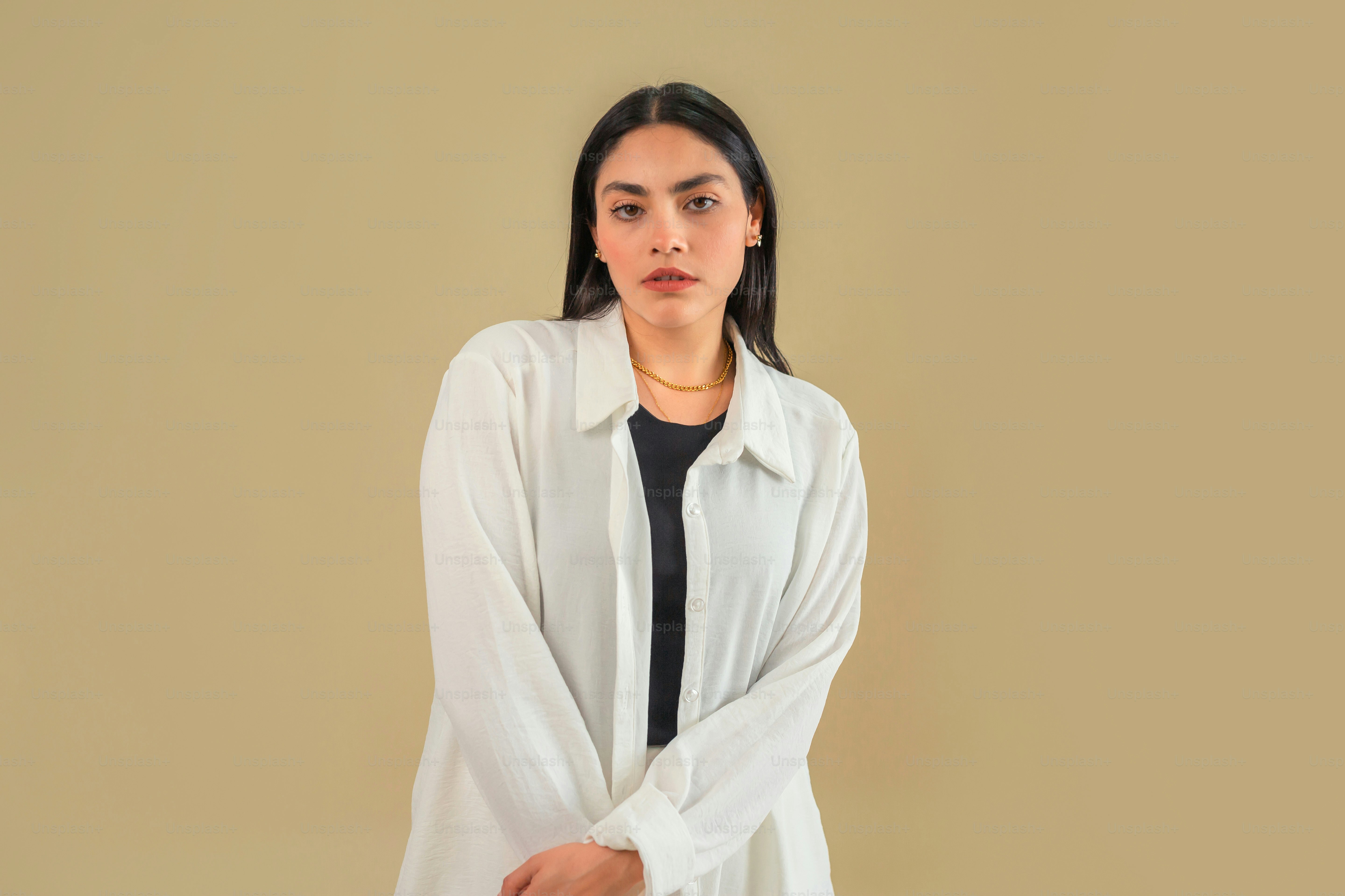 a woman standing in front of a beige wall