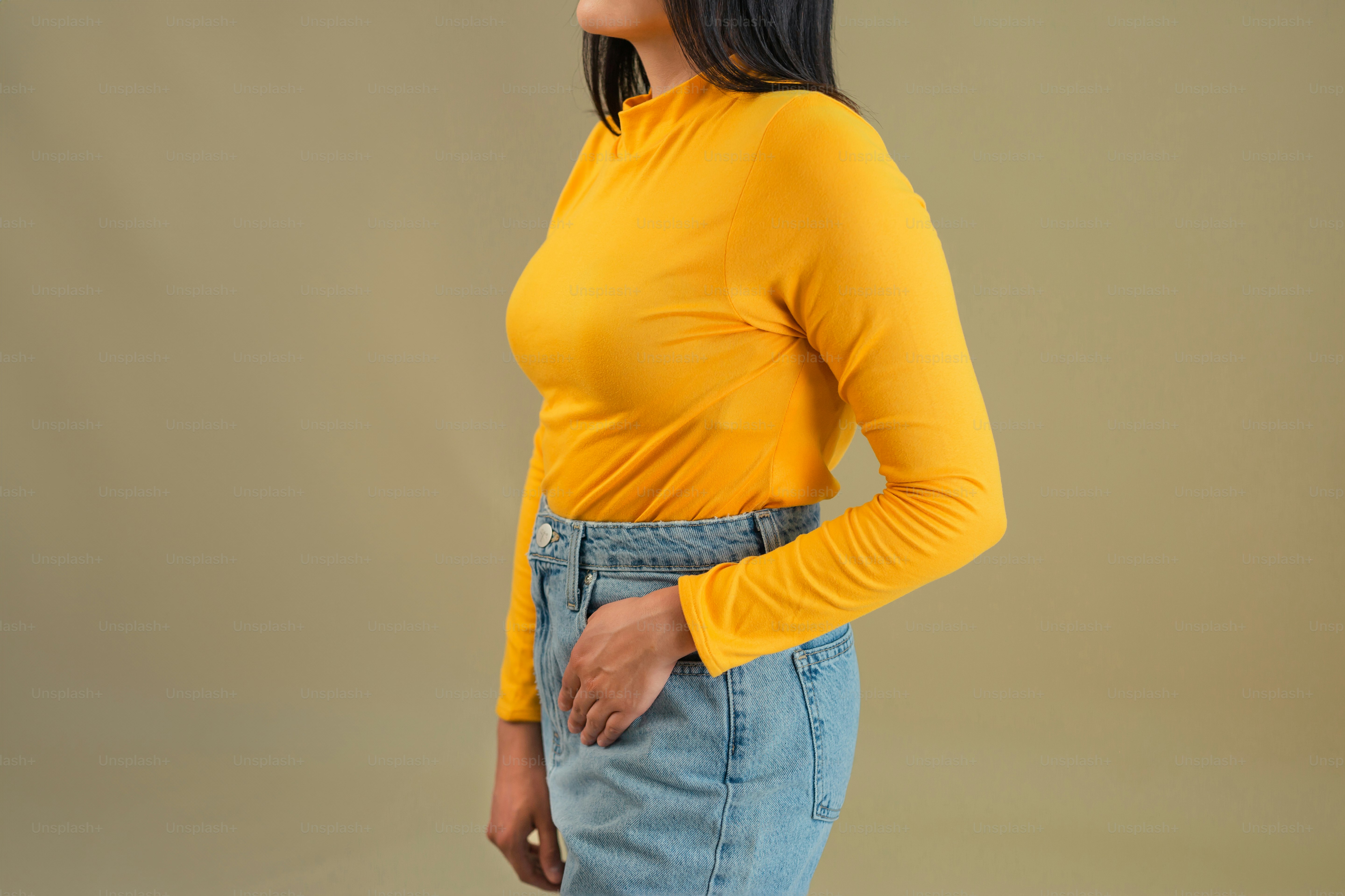 a woman wearing a yellow top and denim skirt