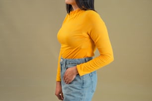 a woman wearing a yellow top and denim skirt