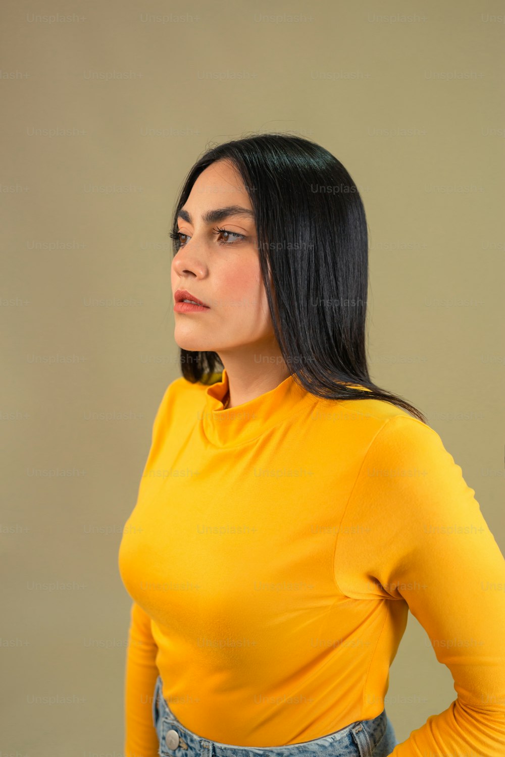 Una donna in una camicia gialla è in posa per una foto
