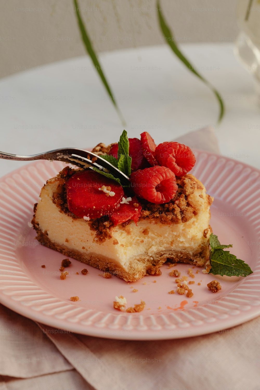 a piece of cheesecake on a pink plate with a fork