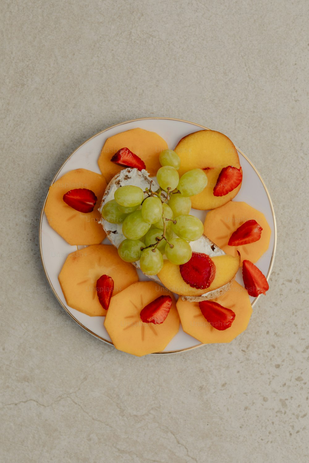 Un plato blanco cubierto con fruta y queso