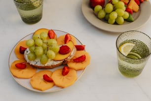 a plate of fruit on a table with a glass of water