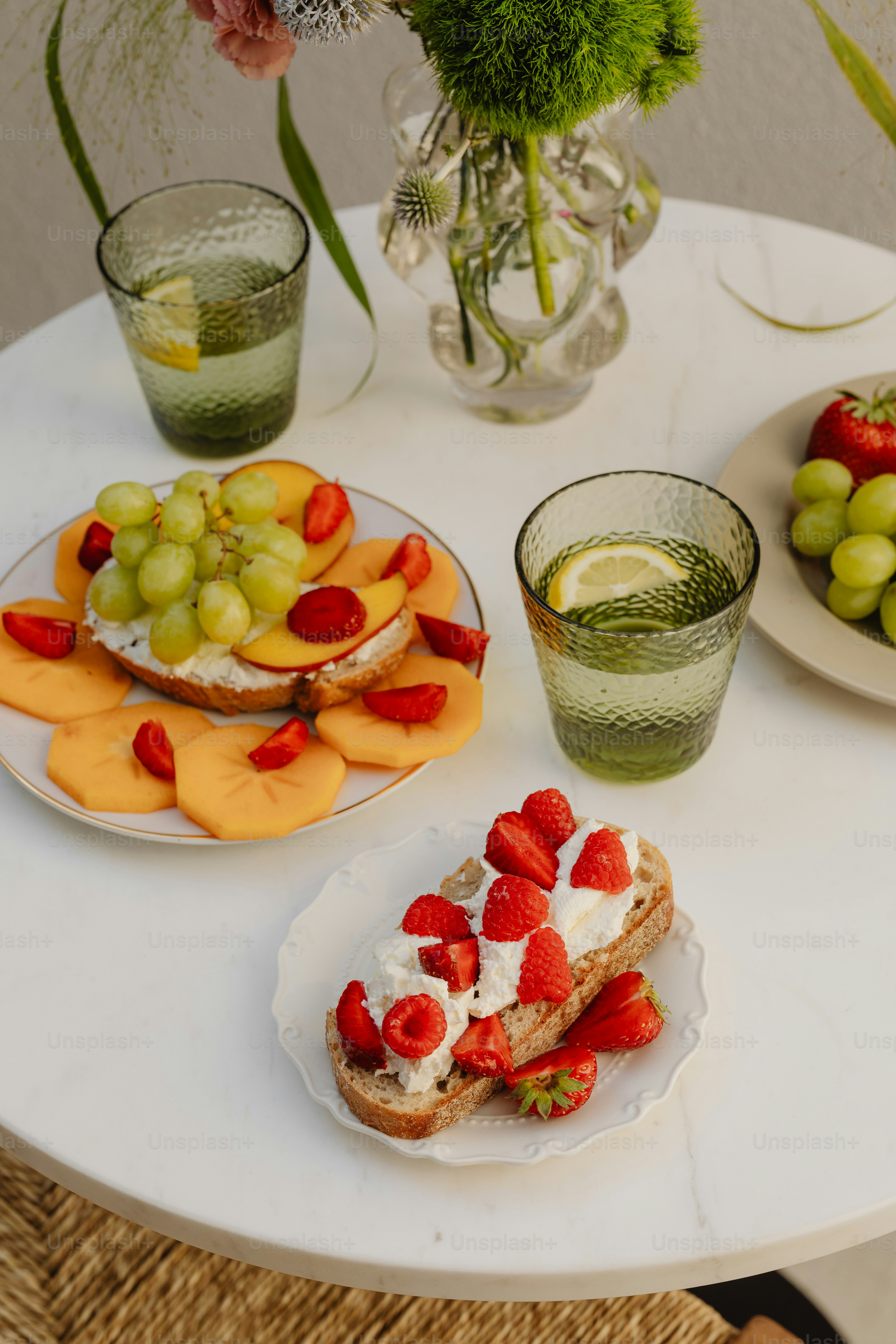 un tavolo sormontato da piatti di frutta e panini