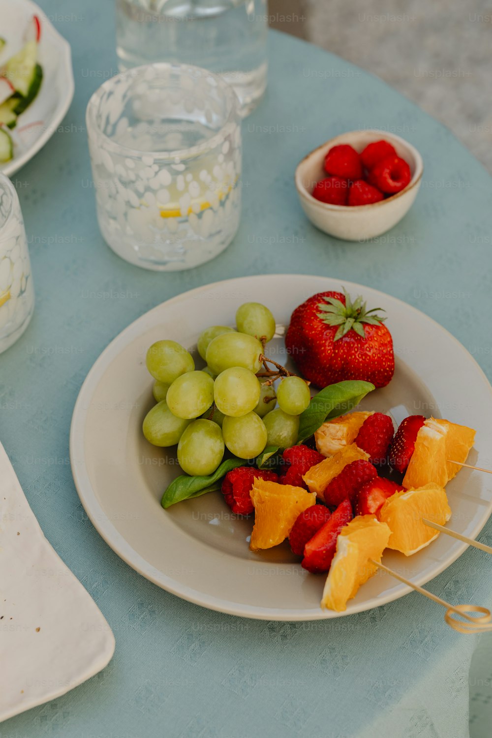 um prato de frutas está sobre uma mesa