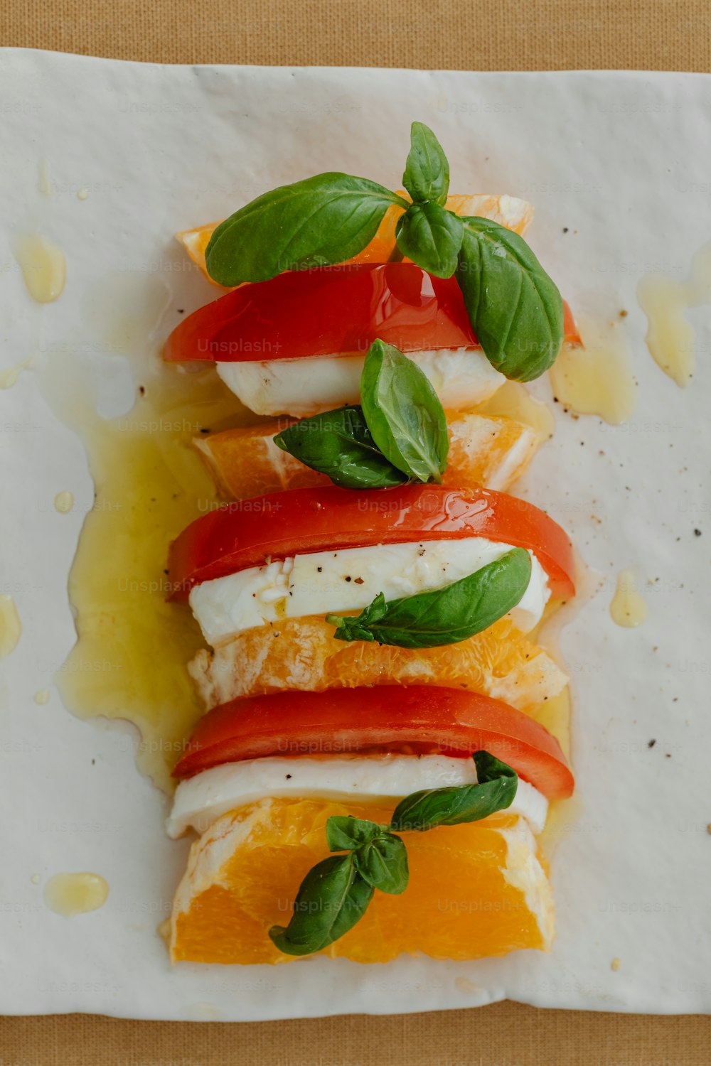 a white plate topped with sliced oranges and tomatoes