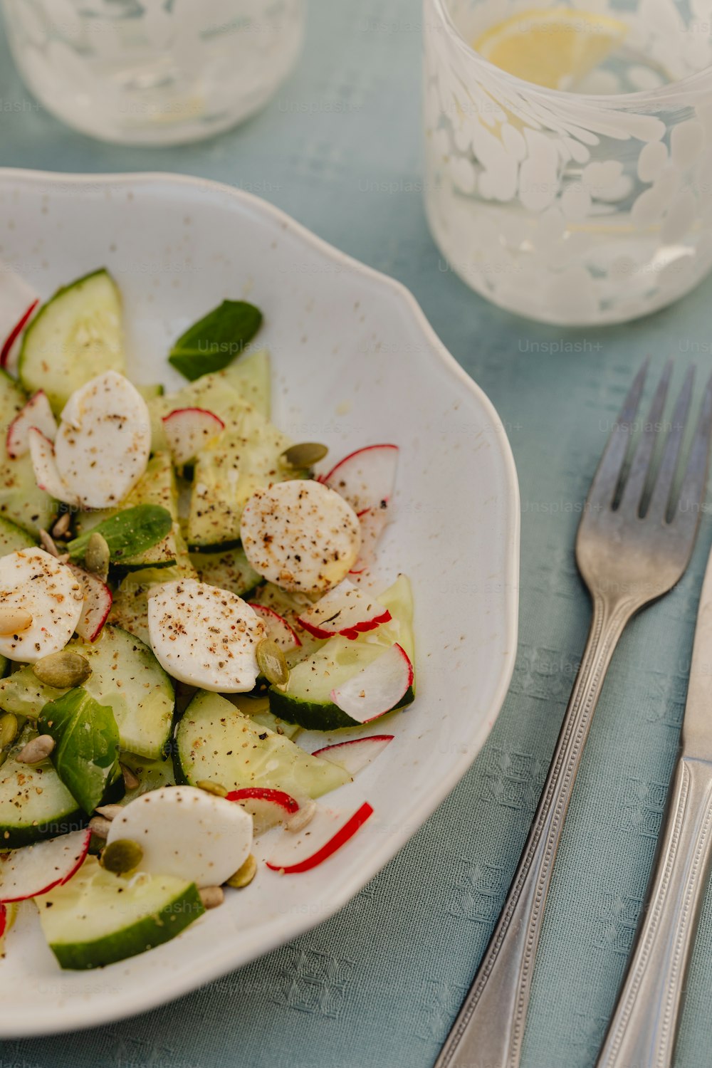 a white plate topped with cucumbers and radishes