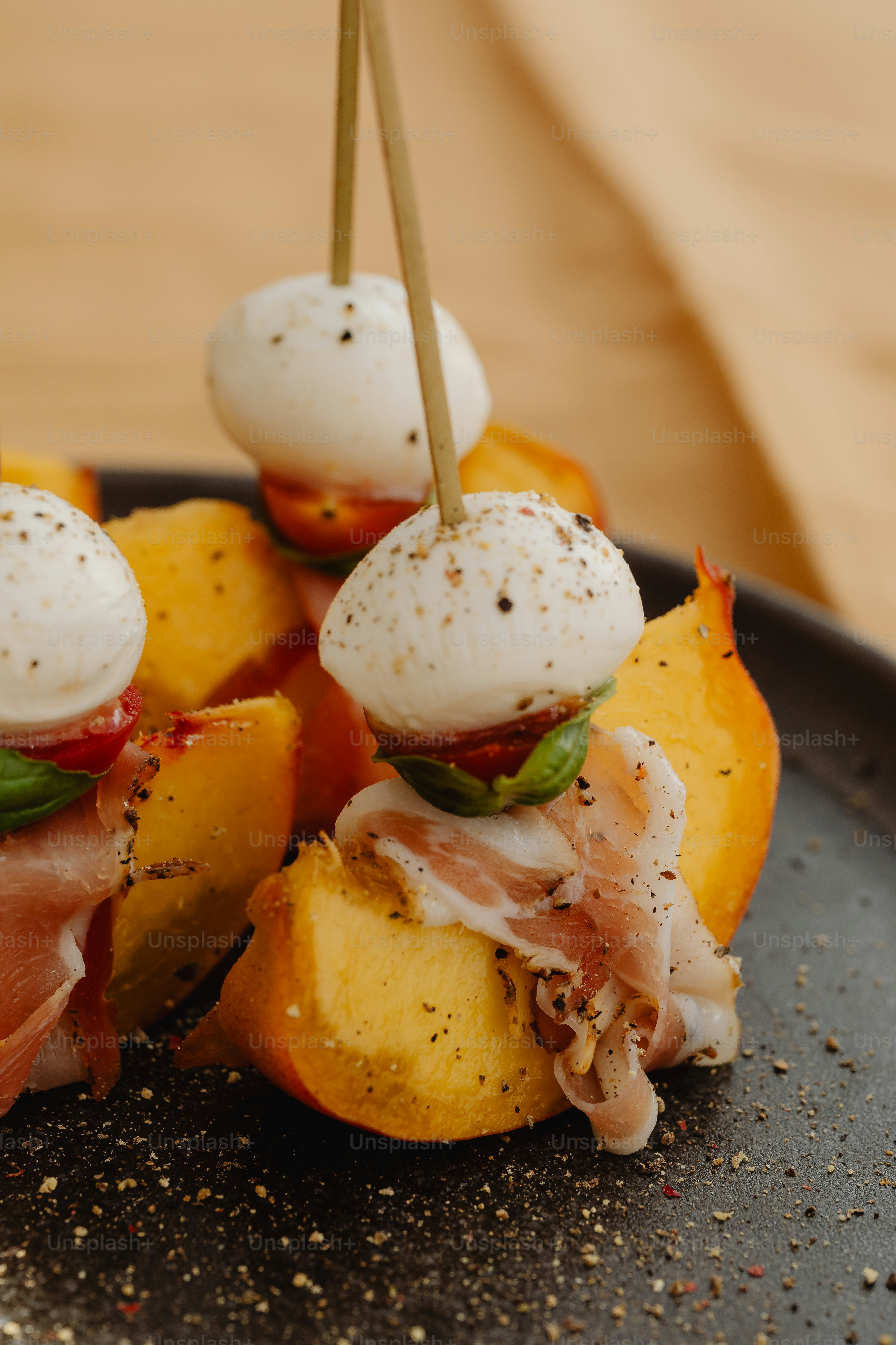 a black plate topped with food on top of a wooden table